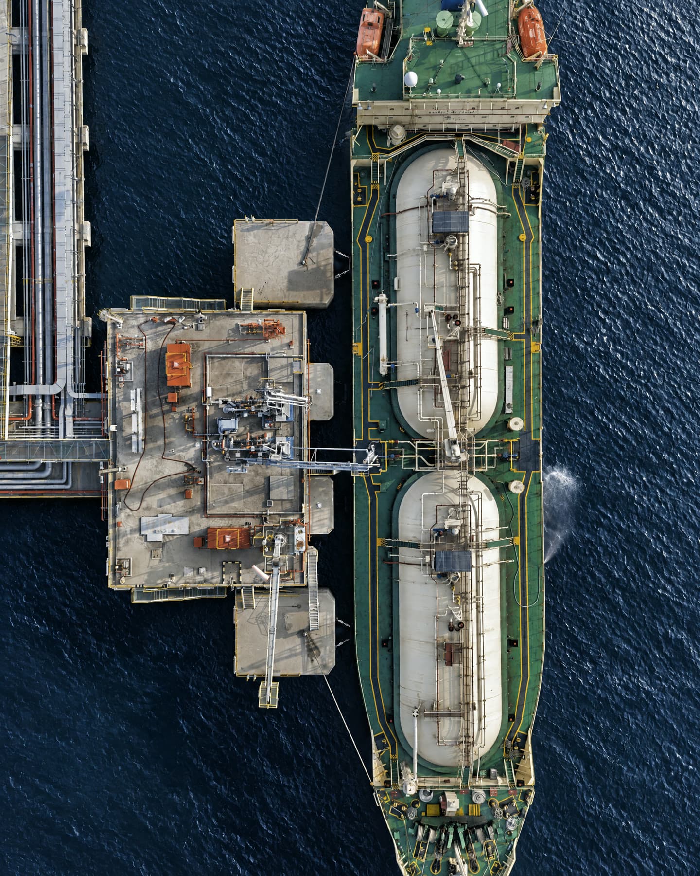 Aerial view of a gas carrier moored beside a loading platform at sea