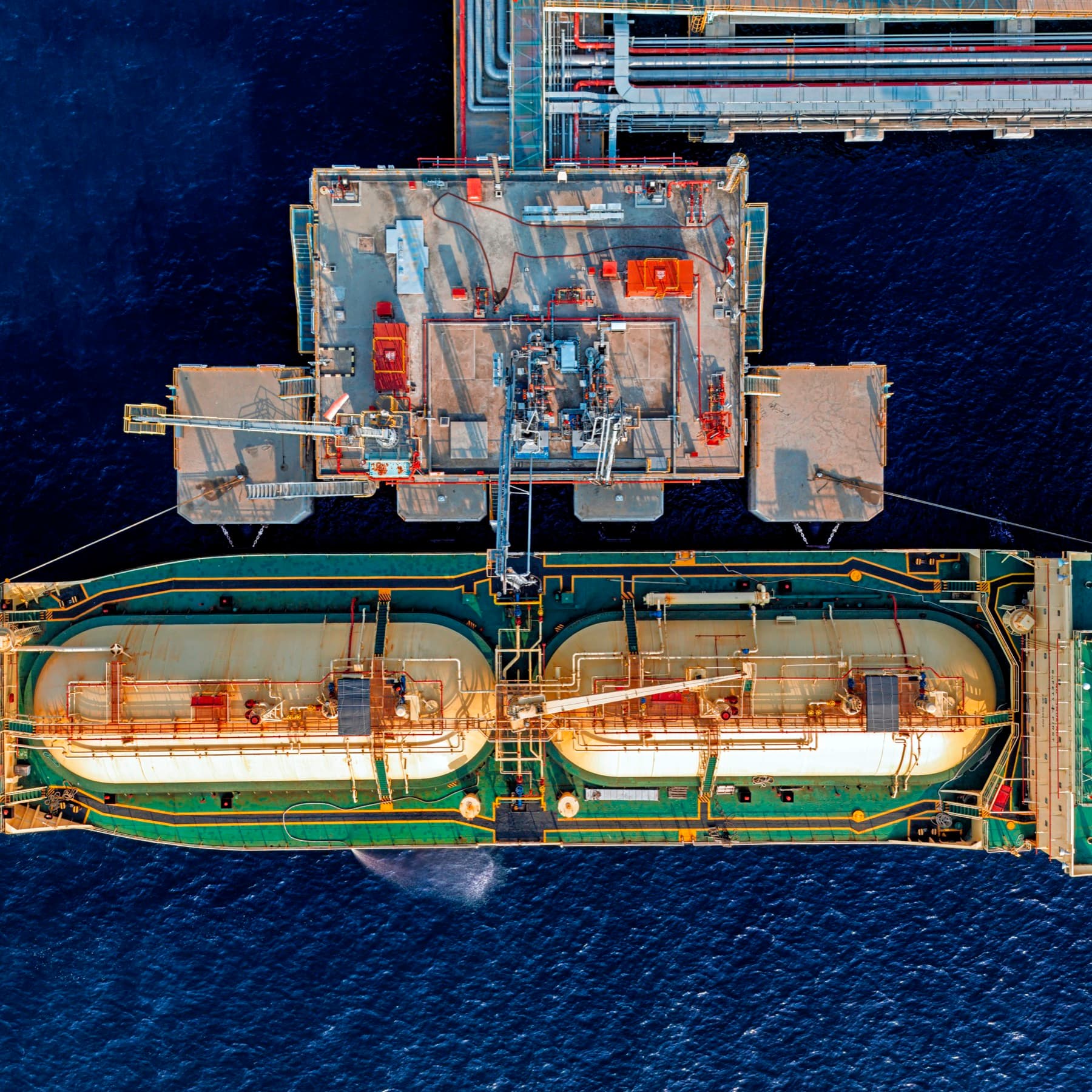 Aerial view of a gas carrier moored beside a loading platform at sea